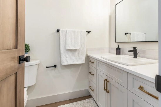 Contemporary powder room in RTM home with white vanity, brass hardware and matte black faucet in Alberta and Saskatchewan