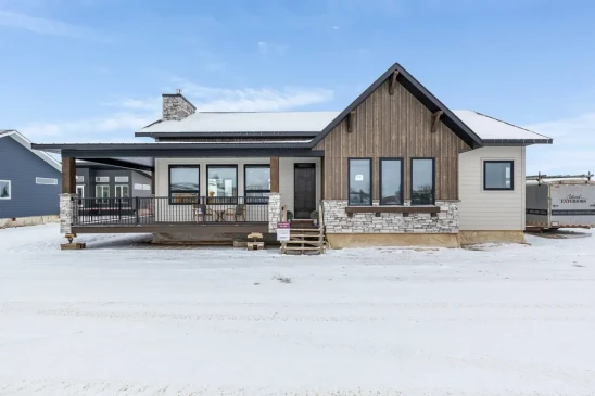 Modern prairie-style RTM home exterior with stone accents, covered porch and wood siding in Alberta and Saskatchewan