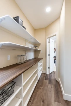 Spacious walk in pantry with open shelving and countertop storage in a custom Ready to Move home.