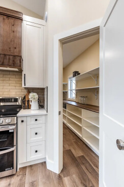 Walk in pantry with custom shelving and easy kitchen access in a thoughtfully designed RTM home.