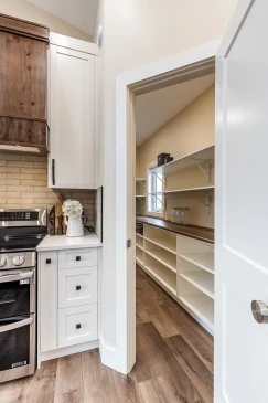 Walk in pantry with custom shelving and easy kitchen access in a thoughtfully designed RTM home.
