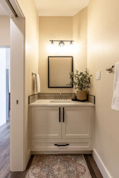 Modern bathroom vanity with custom cabinetry, quartz countertop, and stylish lighting in an RTM home.