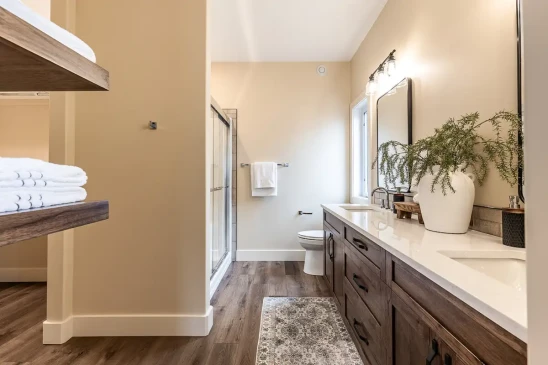 Spacious primary ensuite with double vanity, walk in shower, and custom cabinetry in a Ready to Move home.