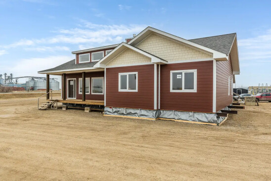 Front corner view of a custom Ready to Move home with durable siding and spacious covered porch by Jade Homes.