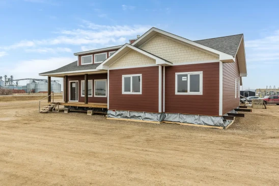 Front corner view of a custom Ready to Move home with durable siding and spacious covered porch by Jade Homes.