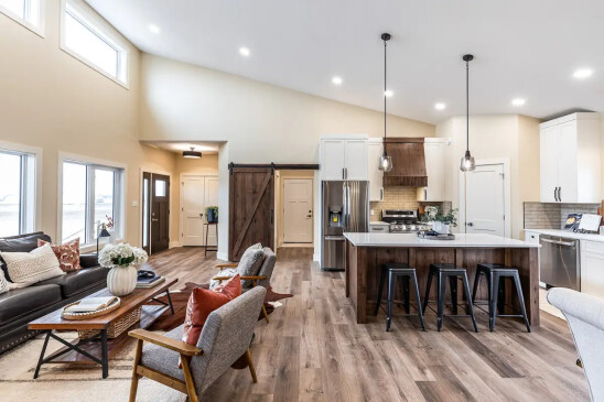 Open concept RTM home featuring a spacious kitchen, living room, and dining area with modern finishes.