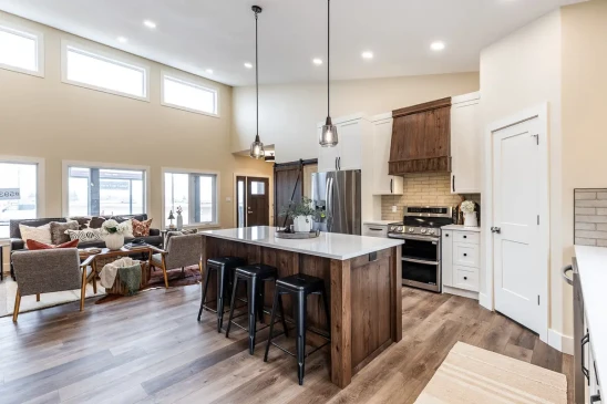 Open concept kitchen and living area in a custom RTM home with vaulted ceilings and premium finishes.