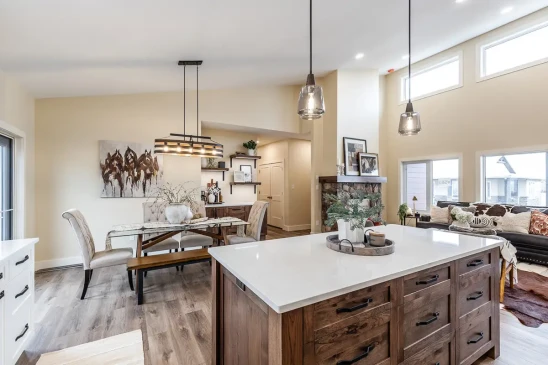 Open concept RTM home featuring a spacious kitchen island, dining area, and vaulted ceilings with modern finishes.