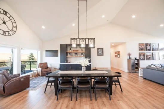 Bright open concept dining room with vaulted ceilings, custom built in cabinetry, and direct access to the covered deck.