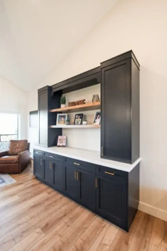 Custom built in living room cabinetry with floating wood shelves, concealed storage, and modern black finish.