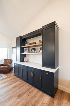 Custom built in living room cabinetry with floating wood shelves, concealed storage, and modern black finish.