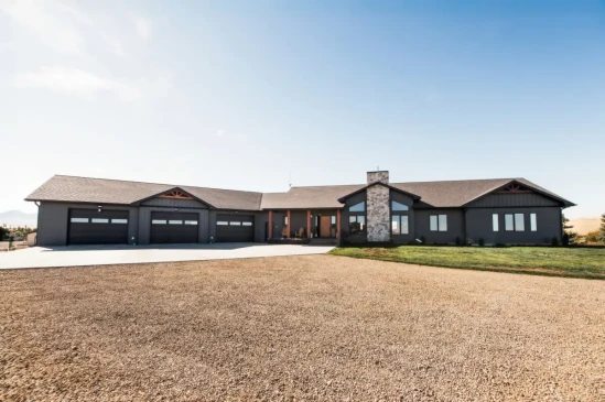 Custom luxury home with attached triple garage, stone chimney, and modern craftsman exterior.
