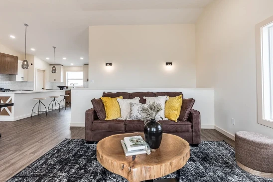 RTM home living room with leather sofa, yellow accent pillows and contemporary wall lighting in Alberta and Saskatchewan