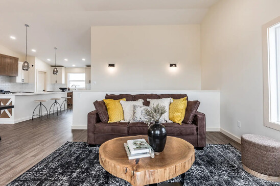 RTM home living room with leather sofa, yellow accent pillows and contemporary wall lighting in Alberta and Saskatchewan