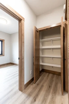 Walk-in closet with built-in shelving and wood trim in RTM home primary suite in Alberta and Saskatchewan