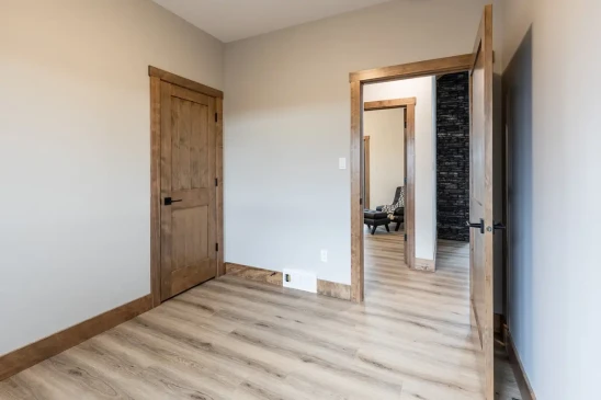 Bright secondary bedroom with wood trim and modern flooring in RTM home in Alberta and Saskatchewan