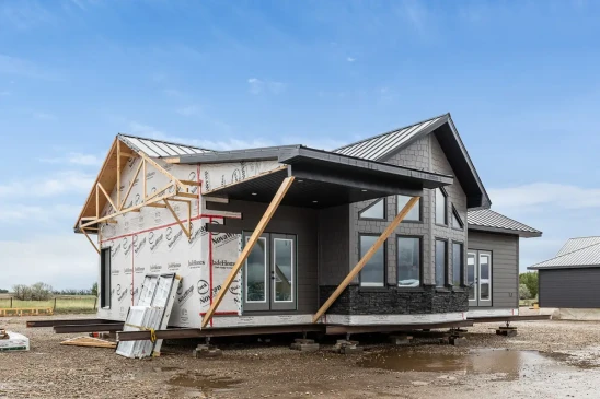 Side view of modern RTM home with vaulted windows and stone exterior, ready-to-move home builder serving Alberta and Saskatchewan