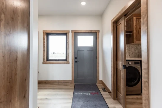 Functional mudroom entry with laundry room access and wood trim in RTM home in Alberta and Saskatchewan