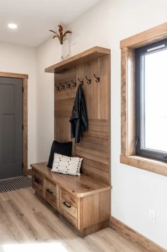 Built-in mudroom bench with coat hooks and storage drawers in RTM home entryway in Alberta and Saskatchewan
