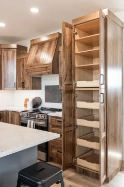 Tall kitchen pantry cabinet with pull-out storage shelves in custom RTM home in Alberta and Saskatchewan