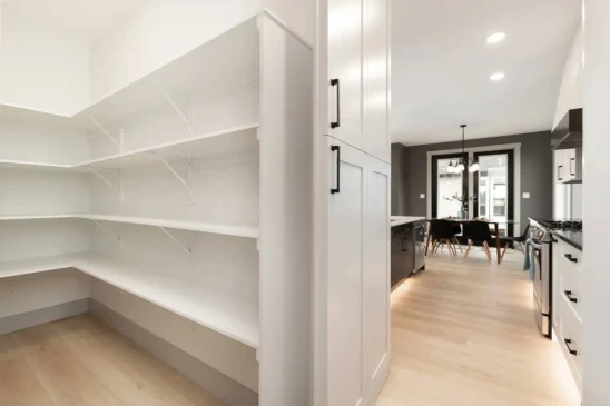 Large walk in pantry with built in shelving providing organized storage in a custom RTM home.