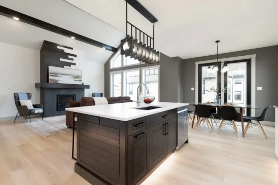 Modern kitchen with large island overlooking the dining area and vaulted living room.