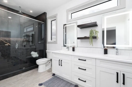 Luxury ensuite bathroom with double vanity, glass walk in shower, and modern custom finishes.
