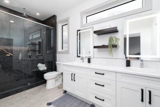Luxury ensuite bathroom with double vanity, glass walk in shower, and modern custom finishes.