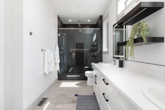 Spacious ensuite bathroom featuring dual sinks, quartz vanity, and large glass walk in shower.