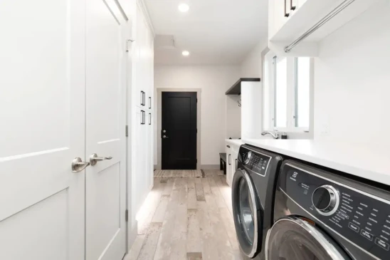 Functional laundry and mudroom with built in storage, utility sink, and modern cabinetry in a Ready to Move home.