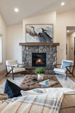 Floor-to-ceiling stone fireplace with rustic wood mantel in ready-to-move bungalow