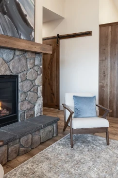 RTM living room with stone fireplace, sliding barn door and wide plank flooring