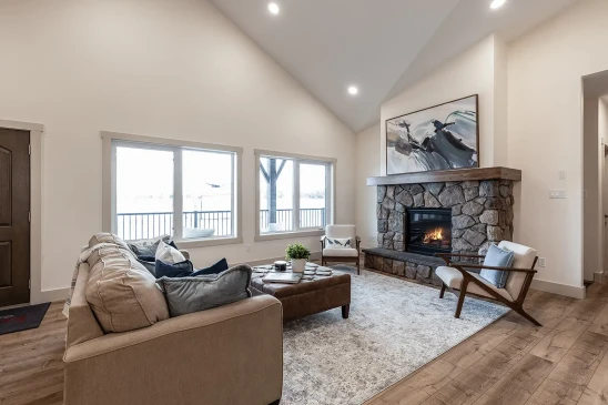 Spacious RTM bungalow living room with sectional sofa and stone fireplace centerpiece